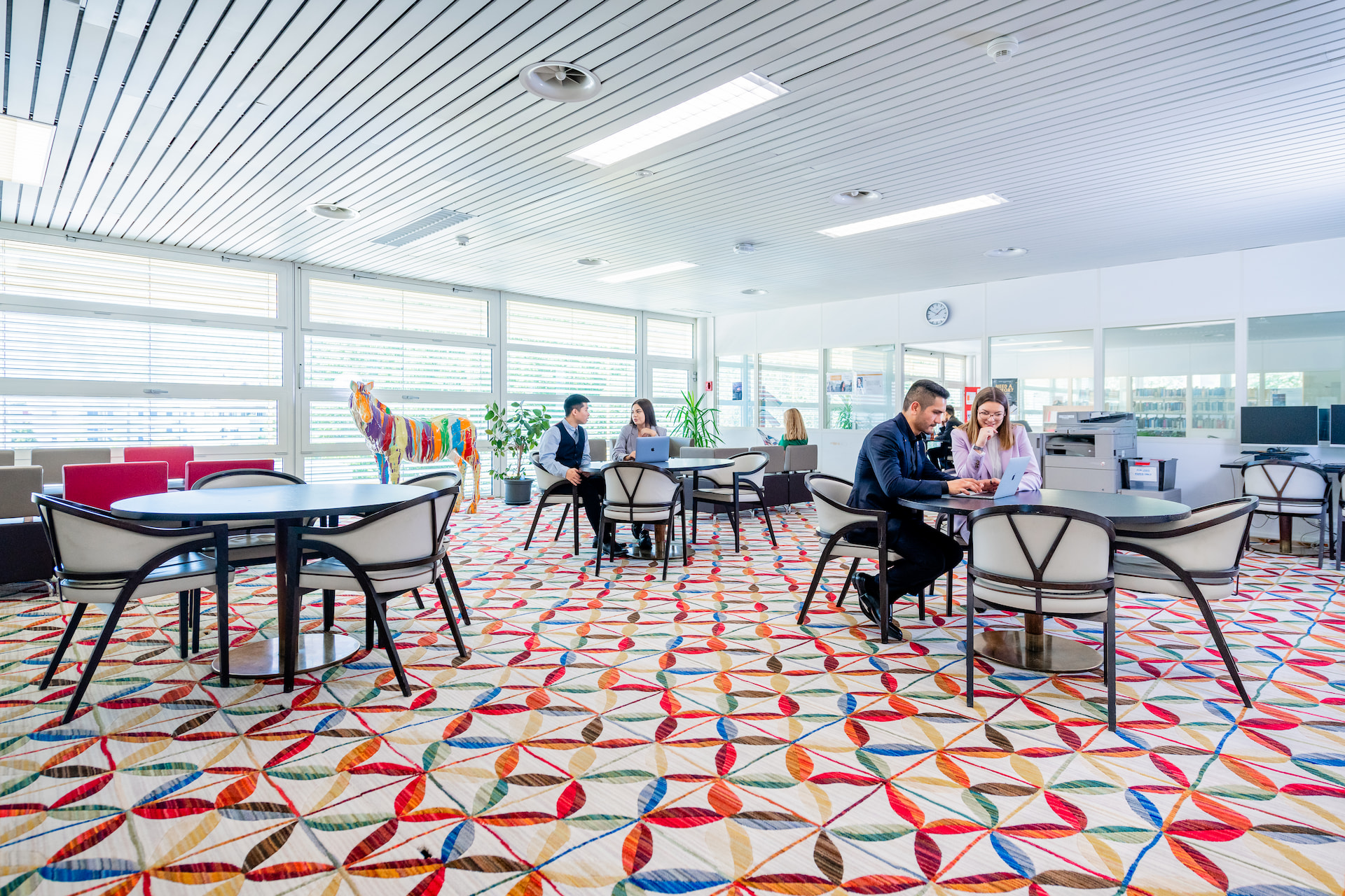A bunch of people working in a business room.