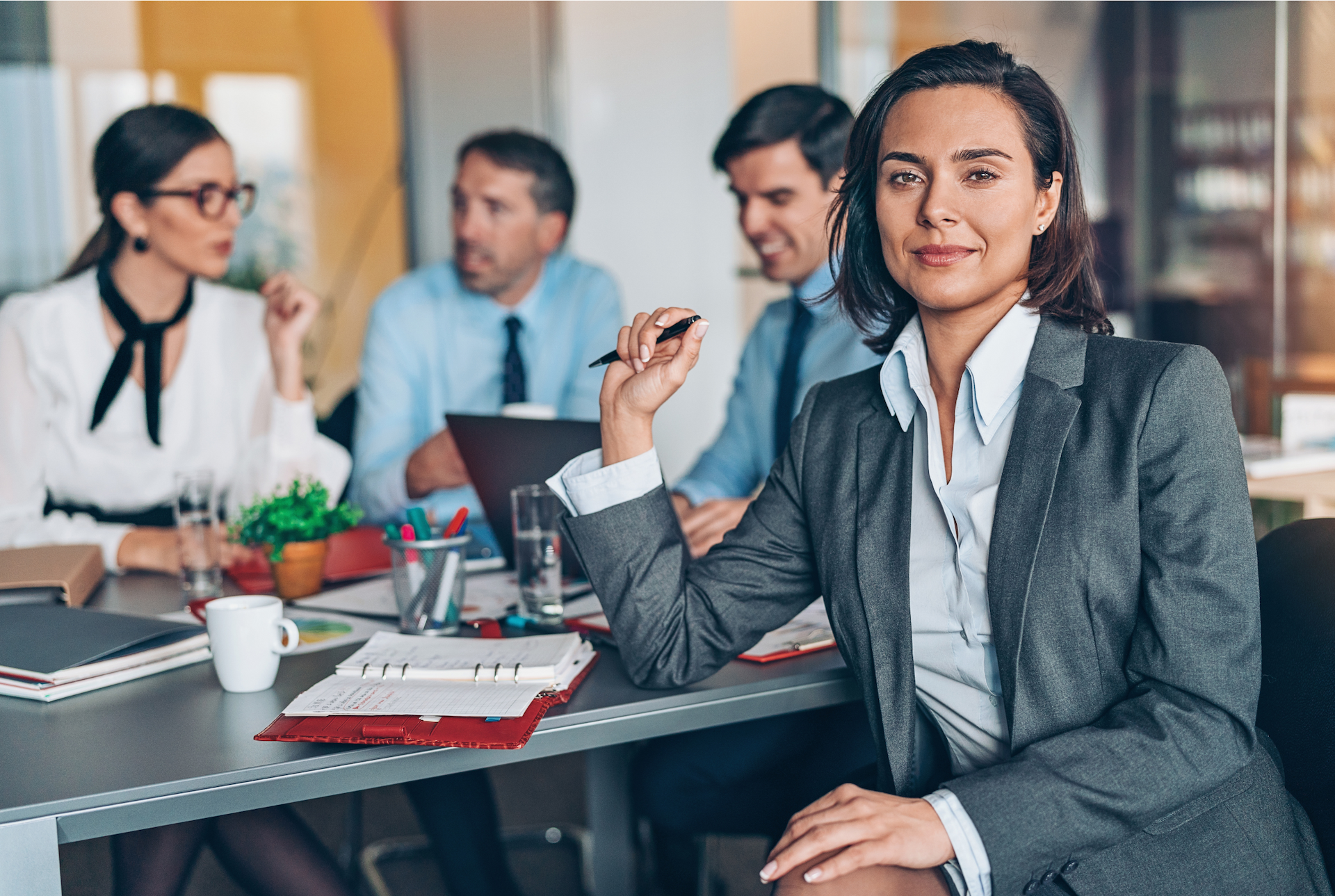 A female leader in a meeting with other colleagues.